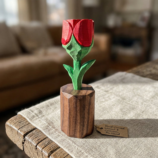 Wooden rose sculpture on a table with a blurred background