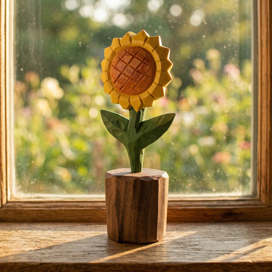 Wooden sunflower sculpture on a wooden base in front of a window with a garden view.